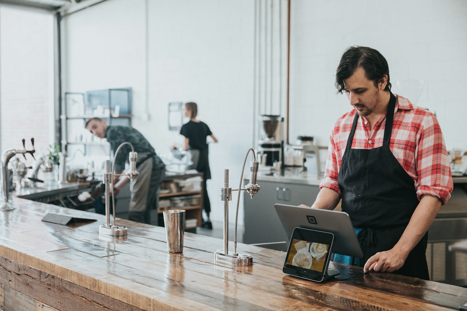 Ladeninhaber an der Kasse mit Tablet