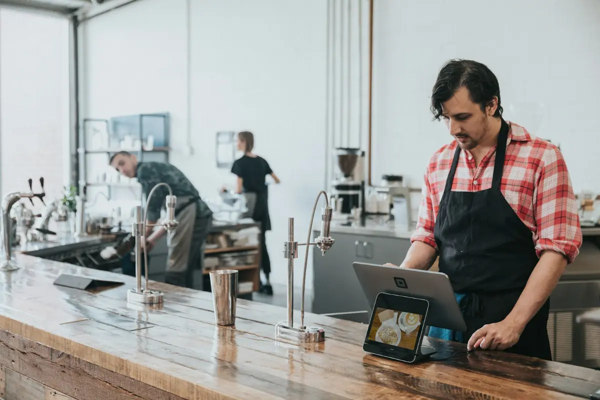 Ladeninhaber an der Kasse mit Tablet